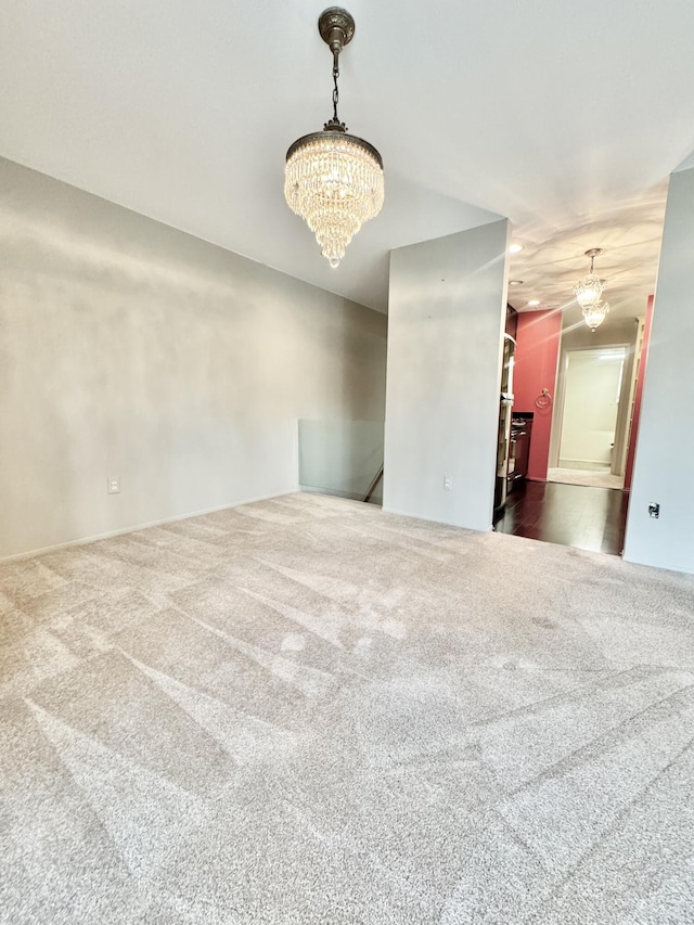 empty room featuring an inviting chandelier and dark carpet