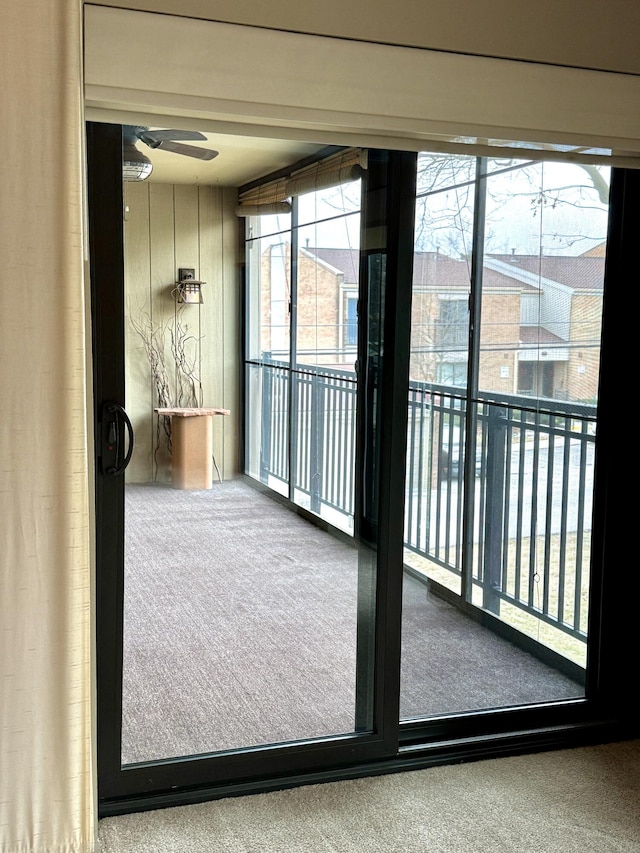 entryway with ceiling fan and carpet