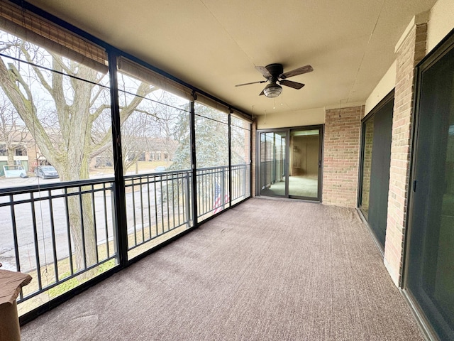 unfurnished sunroom with ceiling fan