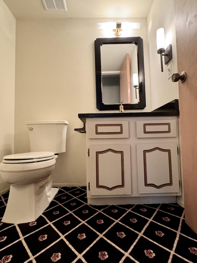 bathroom featuring vanity, tile patterned floors, and toilet