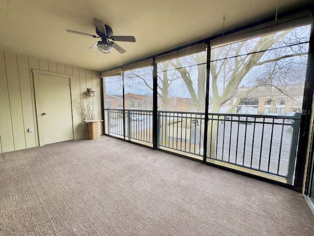 unfurnished sunroom with ceiling fan