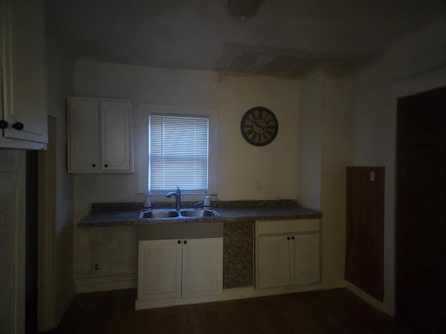 kitchen with dark hardwood / wood-style flooring, sink, and white cabinets