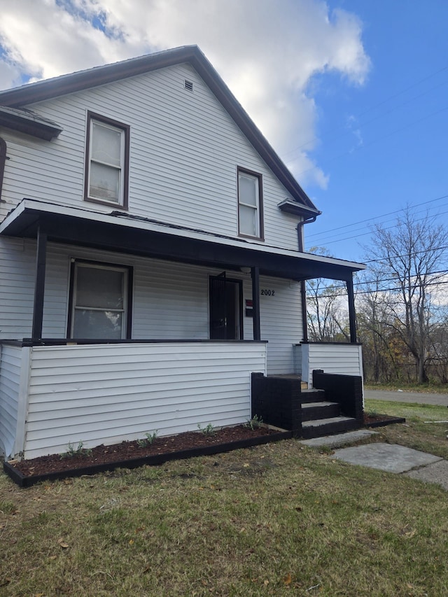 view of front facade featuring a front lawn and covered porch