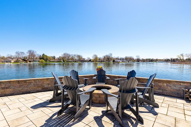 view of patio with a water view and a fire pit