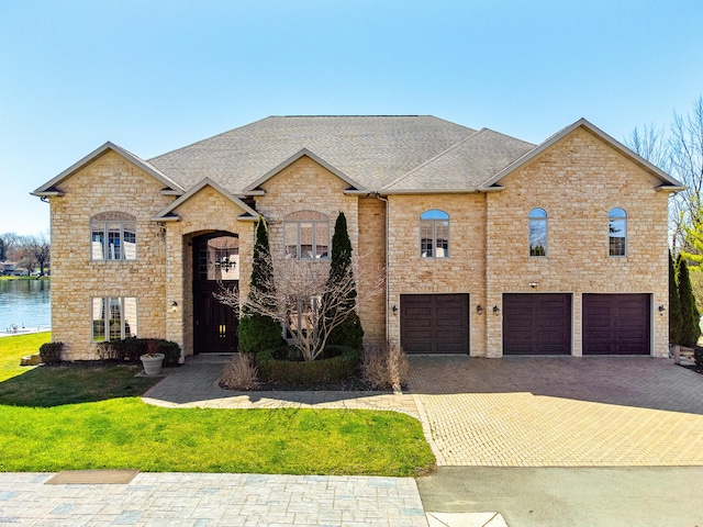 view of front facade with a garage, a water view, and a front yard