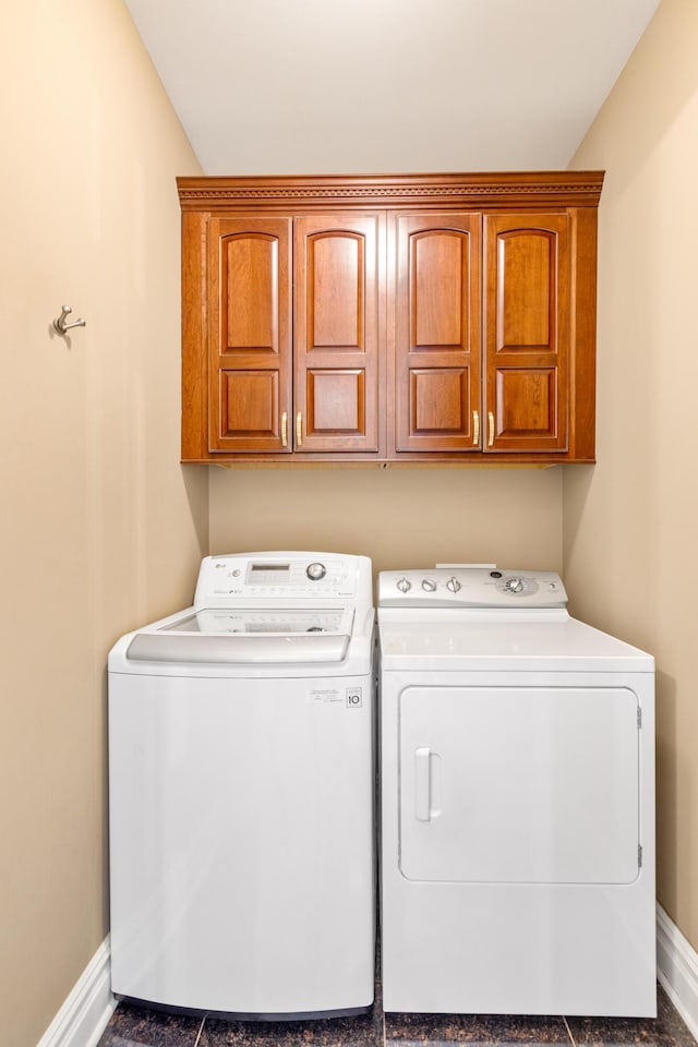 washroom with cabinets and washer and dryer