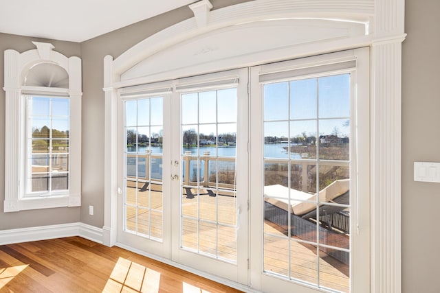 doorway to outside with a water view and hardwood / wood-style floors