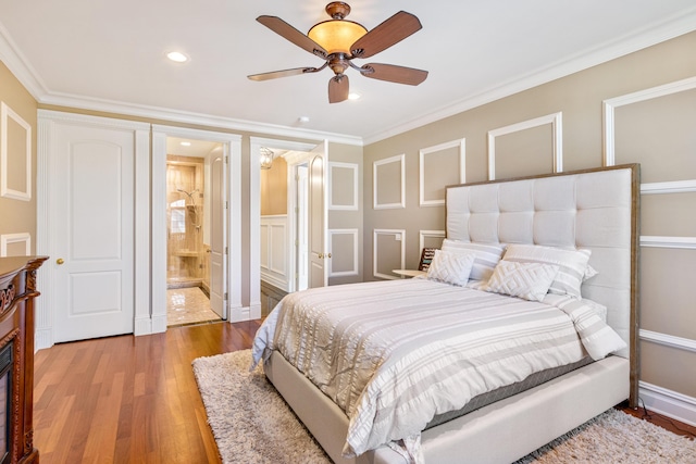 bedroom featuring hardwood / wood-style flooring, ornamental molding, ceiling fan, and ensuite bath