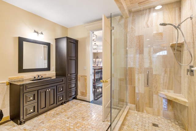 bathroom featuring a chandelier, vanity, and a shower with shower door