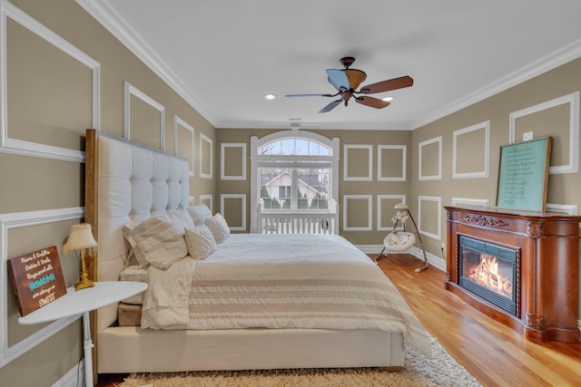 bedroom with ceiling fan, ornamental molding, and wood-type flooring