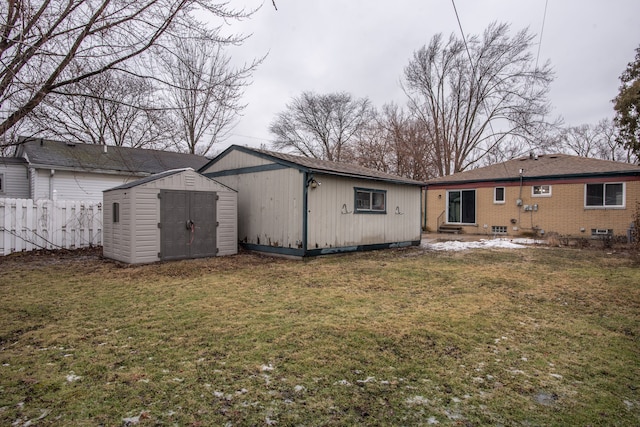 back of property with a shed and a lawn