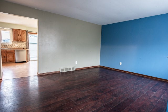 unfurnished room featuring dark hardwood / wood-style flooring and sink