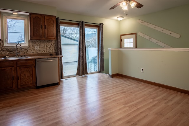 kitchen featuring plenty of natural light, sink, stainless steel dishwasher, and light hardwood / wood-style flooring