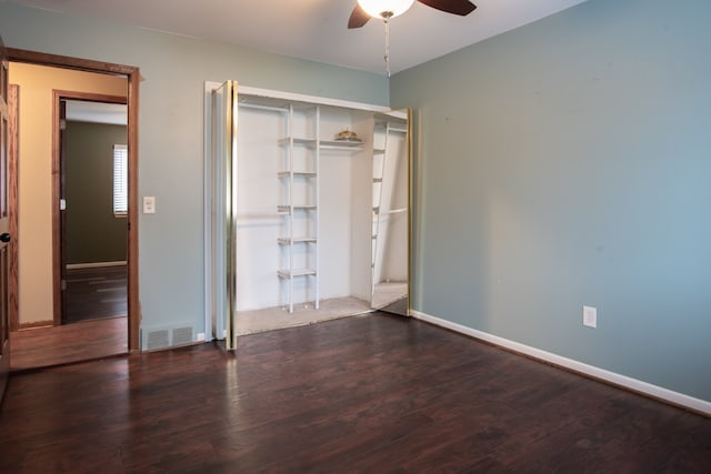 unfurnished bedroom featuring ceiling fan, dark hardwood / wood-style flooring, and a closet