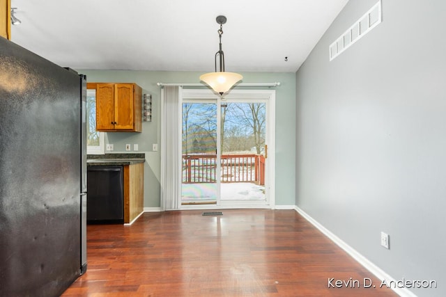 kitchen with dark countertops, visible vents, dark wood-type flooring, baseboards, and black dishwasher