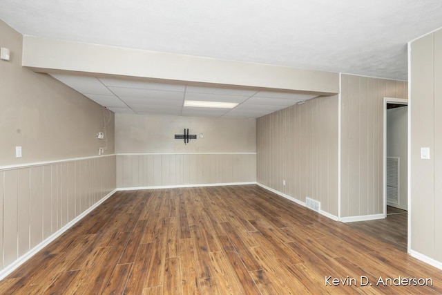 empty room with visible vents, a paneled ceiling, and wood finished floors