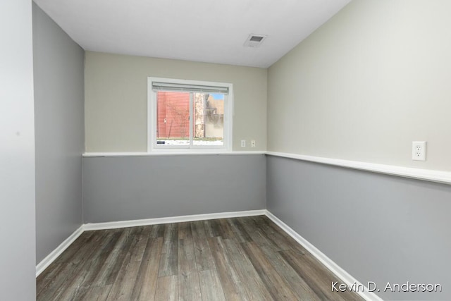 spare room featuring visible vents, baseboards, and wood finished floors