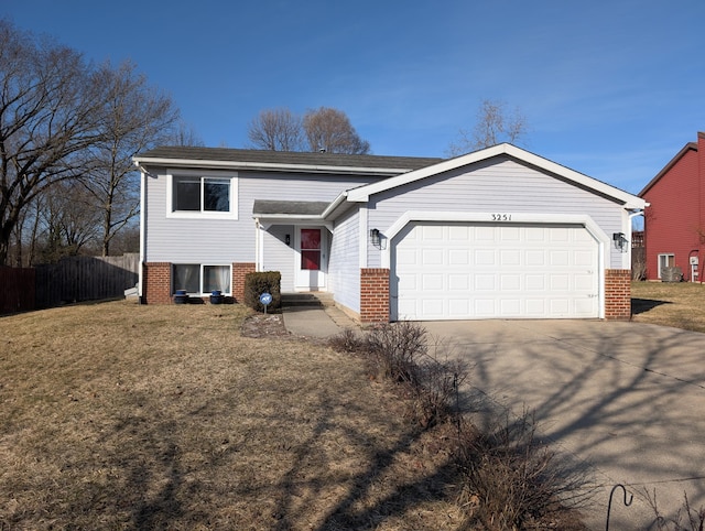 view of front of house featuring a garage, a front yard, brick siding, and driveway