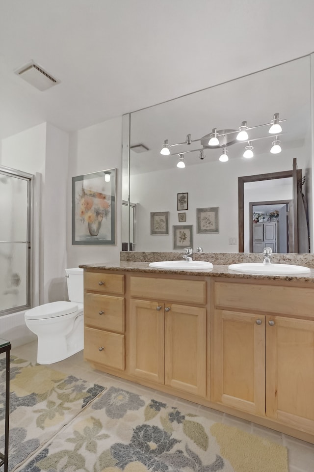 bathroom with an enclosed shower, vanity, tile patterned flooring, and toilet