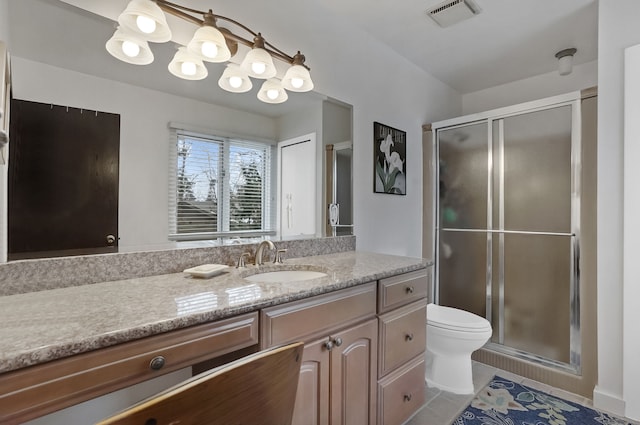 bathroom with vanity, toilet, tile patterned floors, and walk in shower