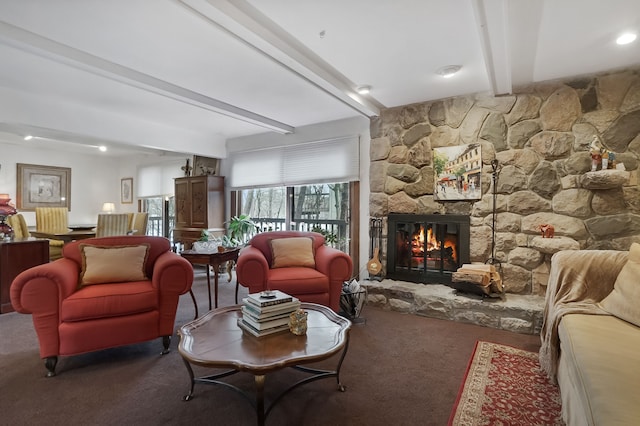 living room featuring beam ceiling, carpet flooring, and a fireplace