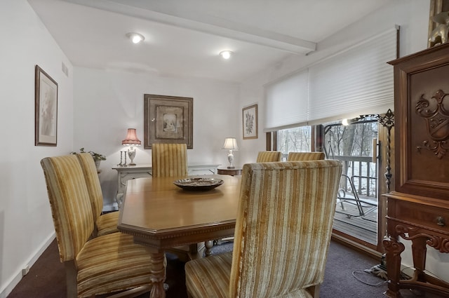 dining area featuring dark carpet and beam ceiling