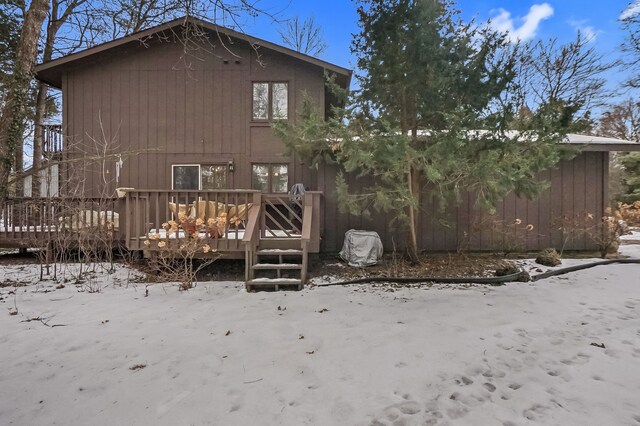 snow covered rear of property featuring a wooden deck