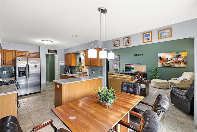 kitchen featuring pendant lighting, tasteful backsplash, stainless steel appliances, and kitchen peninsula