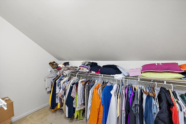 walk in closet with carpet floors and vaulted ceiling