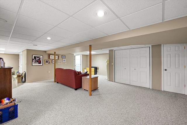 living room featuring a drop ceiling and carpet