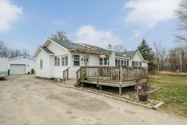 view of front of house featuring a deck, a pergola, a front yard, a garage, and an outdoor structure