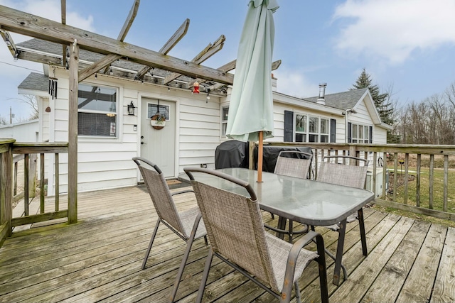 wooden deck featuring area for grilling and a pergola