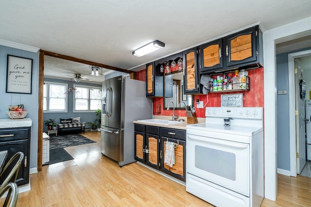 kitchen featuring electric stove, sink, stainless steel fridge, range, and light wood-type flooring