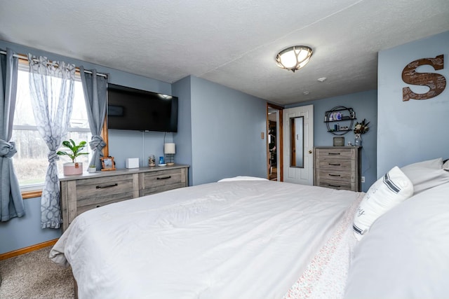 bedroom with multiple windows, carpet, and a textured ceiling