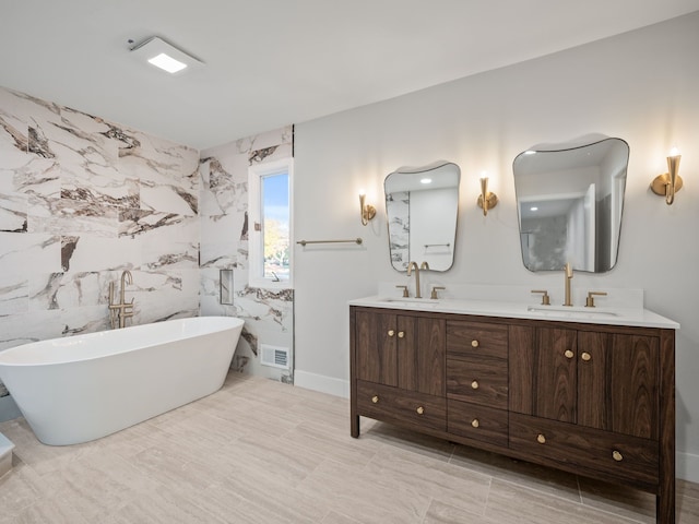 bathroom with vanity, tile walls, and a tub