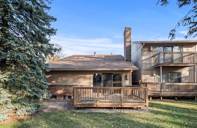 back of property featuring a wooden deck and a yard