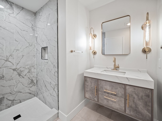 bathroom with vanity, tiled shower, and tile patterned floors