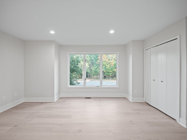 unfurnished bedroom featuring light hardwood / wood-style flooring and a closet