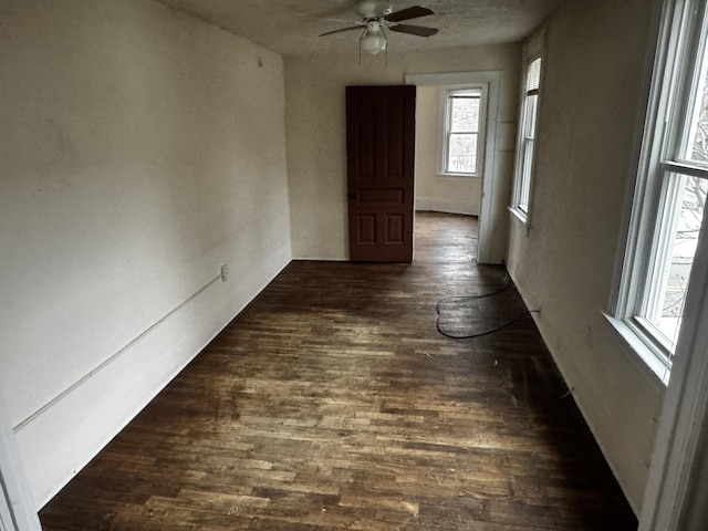 empty room with dark hardwood / wood-style flooring and ceiling fan