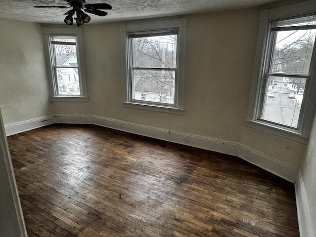 spare room featuring ceiling fan, dark hardwood / wood-style floors, and a textured ceiling