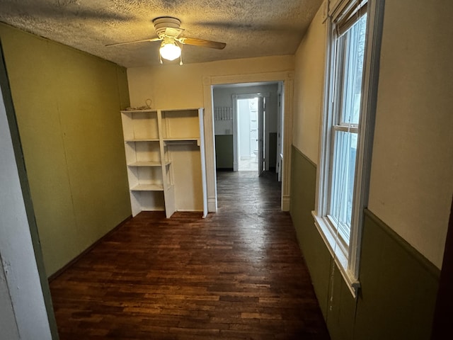 hallway featuring dark hardwood / wood-style floors and a textured ceiling