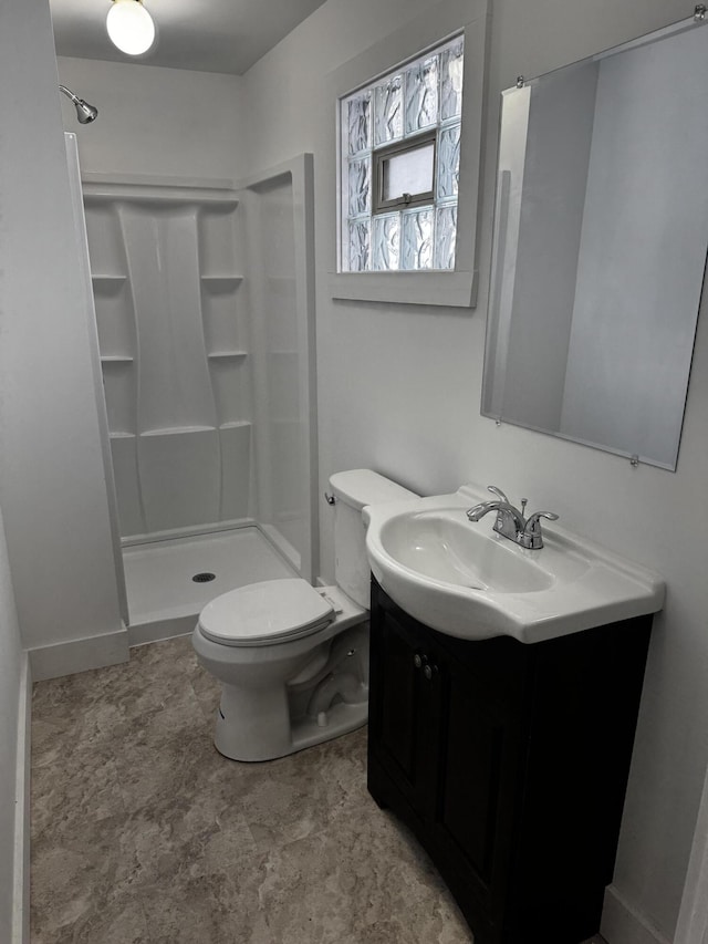 bathroom with walk in shower, vanity, and toilet