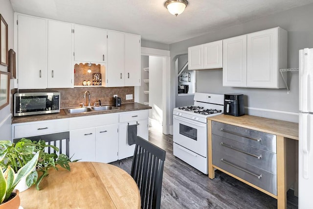 kitchen featuring white cabinetry, sink, backsplash, dark wood-type flooring, and white appliances