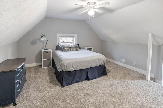 carpeted bedroom featuring a textured ceiling, vaulted ceiling, and ceiling fan