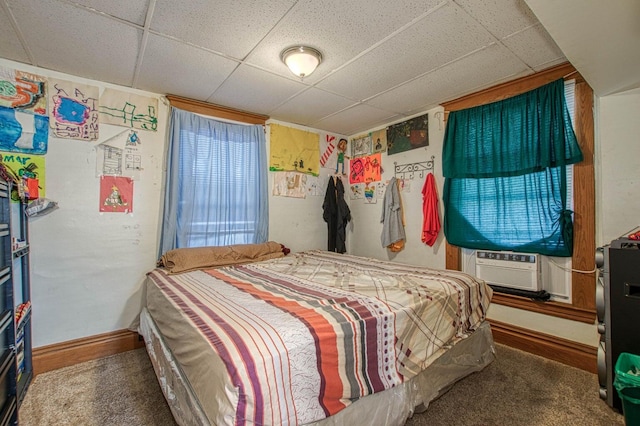 carpeted bedroom with cooling unit and a drop ceiling