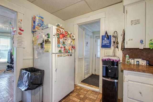 kitchen with white refrigerator and a paneled ceiling