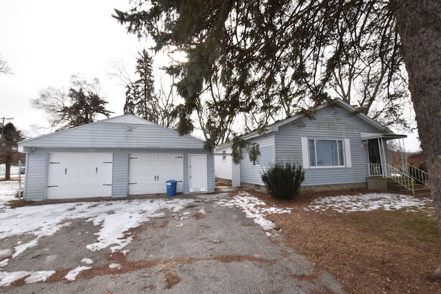 view of front of house featuring a garage and an outbuilding