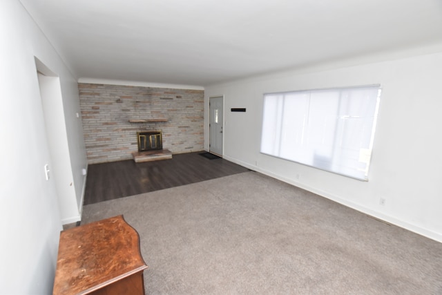 unfurnished living room with dark colored carpet and a fireplace