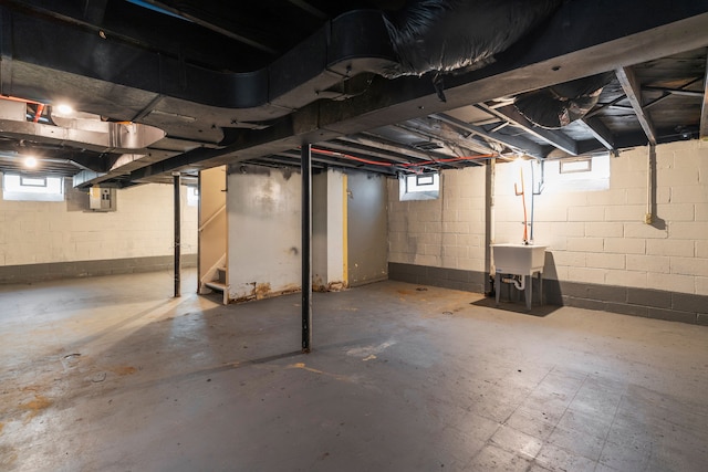 basement featuring sink, a wealth of natural light, and electric panel