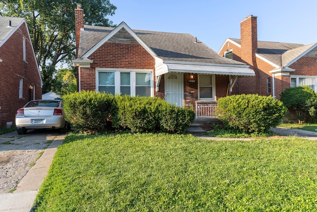 bungalow with a front yard and covered porch